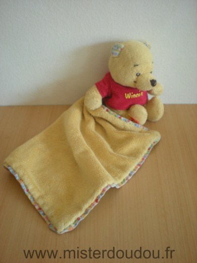 Doudou Ours Disney Winnie jaune tshirt rouge mouchoir qui sort du dos 