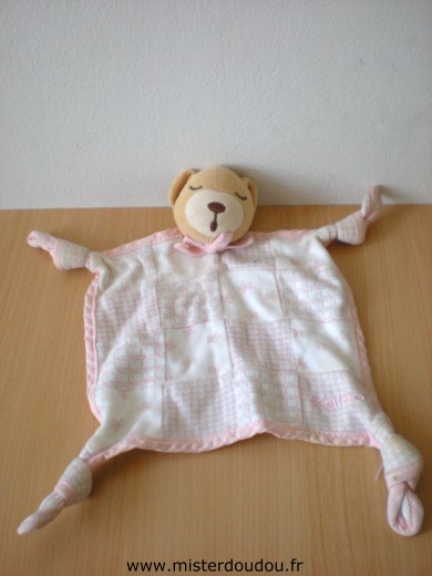 Doudou Ours Kaloo Ours dormeur blanc rose motifs carreaux fleurs Bon état mais un nom est inscrit au stylo sur un liseret rose dessous.