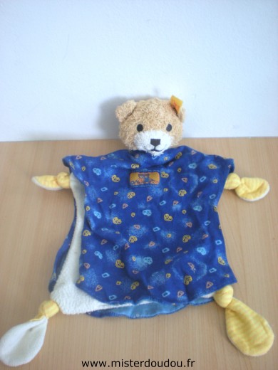 Doudou Ours Steiff Blanc cape bleue marine à motifs jaunes bleus 